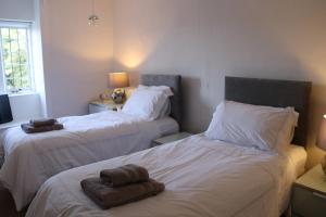 Sortridge Manor - Leat House في تافيستوك: غرفة نوم بسريرين عليها مناشف