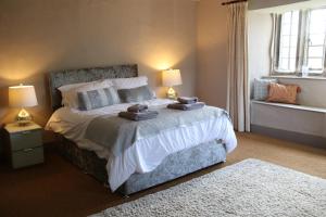 a bedroom with a large bed with towels on it at Sortridge Manor - Leat House in Tavistock