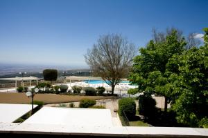 Blick auf einen Pool mit Bäumen und Sträuchern in der Unterkunft Palace Hotel San Michele in Monte SantʼAngelo