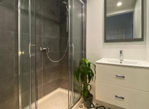 a bathroom with a glass shower and a sink at Sunrise Estudio Zebra, con vistas jardín y mar in Miami Platja