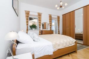 a bedroom with a large bed and a mirror at Apartments Davor in Dubrovnik
