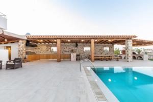 a patio with a swimming pool and a building at Ktima Kritikos in Paradeísion