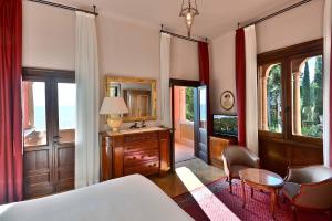 a bedroom with a bed and a table and chairs at Hotel Villa Fiordaliso in Gardone Riviera