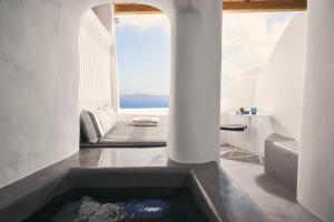 a bathtub in a room with a view of the ocean at Alisaris Cave Suites in Oia +71 photos