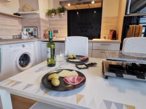 una cucina con tavolo, bottiglia di vino e frutta di LE DUPLEX - Hyper centre - Gare - Wifi - Netflix - Disney + ad Annecy Altre 39 foto