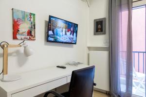 a desk with a television on a white wall at K2 SUITE in Thessaloniki