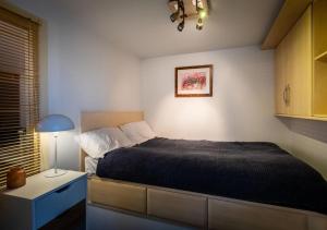 a bedroom with a bed and a lamp and a cabinet at Lux Duplex Apartment 19th Century Chapel Wakefield Centre in Wakefield