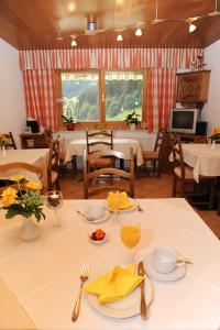 un comedor con una mesa blanca con servilletas amarillas en Haus Schönlechner, en Gaschurn