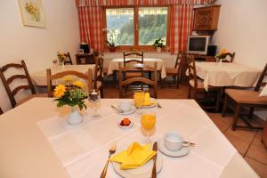 a dining room with tables and chairs and a table with food at Haus Schönlechner in Gaschurn