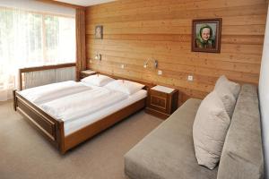 ein Schlafzimmer mit einem großen Bett an einer Holzwand in der Unterkunft Haus Schönlechner in Gaschurn