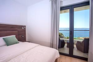 Schlafzimmer mit einem Bett und einer Glasschiebetür in der Unterkunft Seaview holiday home Lemona in Duće