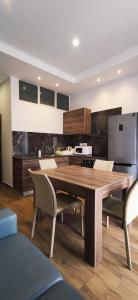une grande cuisine avec une table et des chaises en bois dans l'établissement Diamonds Luxury Apartments, à Marsalforn