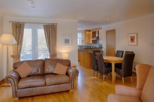 a living room with a couch and a table at Links Apartment in Brora