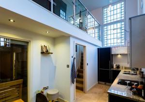 a large kitchen with a staircase in a loft at Lux Duplex Apartment 19th Century Chapel Wakefield Centre in Wakefield