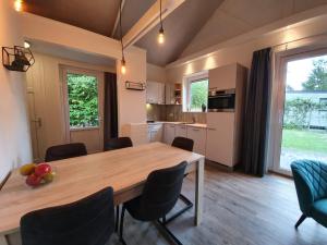 Vakantiehuis, Camping Alkenhaer في أبلسخا: مطبخ وغرفة طعام مع طاولة وكراسي خشبية