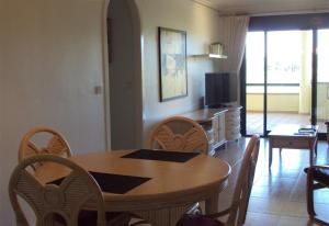 un soggiorno con tavolo, sedie e TV di Luxurious flat with splendid views a Orihuela Costa
