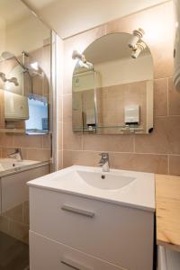 a bathroom with a white sink and a mirror at Le Thalasso in Amélie-les-Bains-Palalda +4 photos