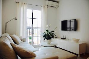 a living room with a couch and a table and a tv at Fantastic 1 bedroom apartment in the centre of Nerja in Nerja