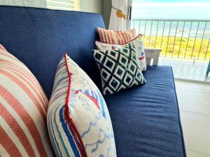 un sofá azul con varias almohadas en True North West Coast, en St Helena Bay