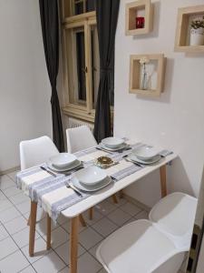 een witte tafel met witte borden en borden erop bij Wohnen am Main - gemütlicher Altbau, zentral in Würzburg