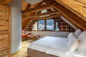 a bedroom with a white bed in a room with wooden ceilings at Das Fort Boutique in Râşnov
