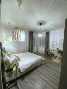 a bedroom with a white bed and a desk at Berg Apartment in Braşov