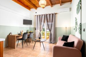 uma sala de estar com um sofá, uma mesa e cadeiras em Eagle's Nest City Apartments em Aigio