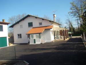 uma grande casa branca com um telhado laranja em Les Gîtes Malidri em Pontonx-sur-lʼAdour