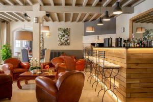 a bar with brown leather chairs and a bar counter at Best Western Le Val Majour in Fontvieille