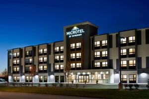 un edificio de oficinas con un cartel encima en Microtel Inn & Suites by Wyndham Aurora en Aurora