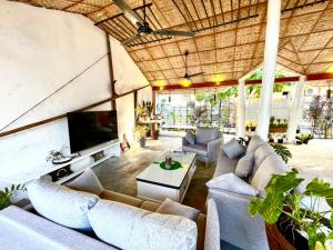 una gran sala de estar con sofás y TV. en Dhiffushi Island Villa en Dhiffushi