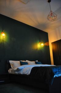 a bedroom with a bed with two lights on the wall at Celebrity Apartment Brasov in Braşov