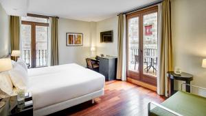 um quarto de hotel com uma cama e uma varanda em Sercotel Puerta de la Catedral em Salamanca
