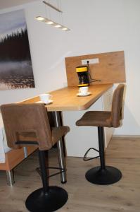 un escritorio con 2 sillas y una mesa con tazas. en Ferienwohnung mit Aussicht, en Enzklösterle
