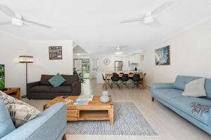 a living room with two blue couches and a table at Marcoola Beach Resort in Marcoola