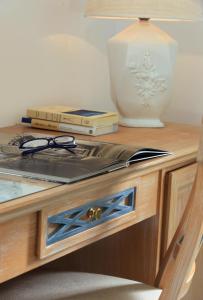 a table with books and a vase on top of it at Hotel Al Mulino in Anacapri