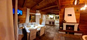 a dining room with a table and a fireplace at LAGO BLANCO in Klusek Biały