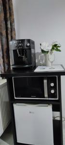 a black table with a microwave and wine glasses at Smart studio sibiu in Sibiu