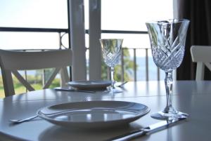 a table with two wine glasses and a plate on it at Fehmarn-OstseeferienStrandresidenz VogelflugPenthouse 15 in Fehmarnsund