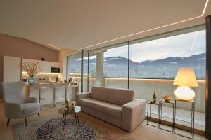 a living room with a couch and chairs and a large window at Penthouse I CIPRESSI in Postal