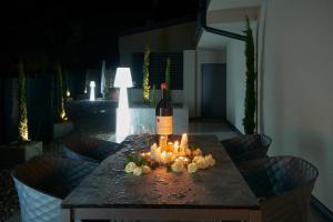 una bottiglia di vino seduta su un tavolo con candele di Penthouse I CIPRESSI a Postal