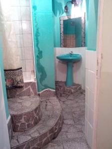 y baño con lavabo azul y espejo. en Sárkány Lak, en Diósd