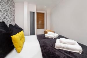 a bedroom with a bed with yellow and white pillows at Apartment 1 The Keyes- Stylish & Spacious Apartment With Free Parking in York