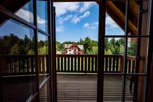 een uitzicht van de binnenkant van een veranda kijkend naar een huis bij Pohorje Village Wellbeing Resort - Forest Apartments Videc in Hočko Pohorje