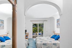 a bedroom with two beds and a mirror at Hotel Al Mulino in Anacapri +37 photos