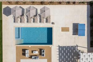 an overhead view of a building with a swimming pool at Evaero Villas I, II, III, IV - an ever-so inviting escape, By ThinkVilla in Sfakaki