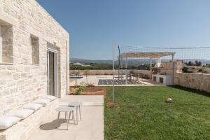 a stone house with a view of the yard at Evaero Villas I, II, III, IV - an ever-so inviting escape, By ThinkVilla in Sfakaki