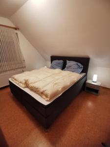 ein Schlafzimmer mit einem Bett mit einem schwarzen Bettrahmen in der Unterkunft FeWo-Norden in Norden