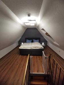 ein Schlafzimmer mit einem Bett auf einem Dachboden in der Unterkunft FeWo-Norden in Norden