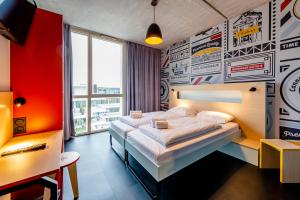 a bedroom with a large bed with a wall covered in stickers at MEININGER Hotel Bordeaux Gare Saint-Jean in Bordeaux